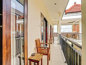 un balcon avec deux chaises et une table dans l'établissement Samudra Homestay, à Kuta 7 autres photos