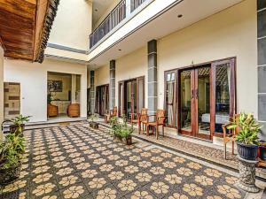 une terrasse avec des tables et des chaises dans une maison dans l'établissement Samudra Homestay, à Kuta