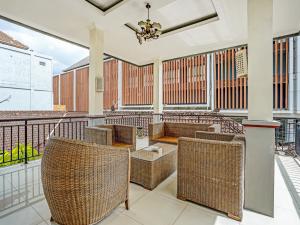 a balcony with wicker furniture and a chandelier at Samudra Homestay in Kuta