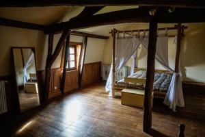 a bedroom with a canopy bed and a wooden floor at Chambres d'hôte en Dordogne in Beauronne