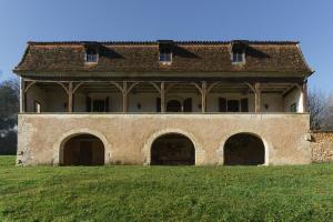 a large building with arches on a grass field at Chambres d'hôte en Dordogne in Beauronne