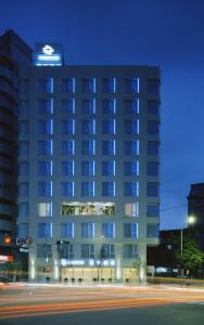 a tall building at night with a street in front of it at Ambience Hotel Taipei in Taipei