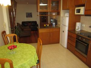 eine Küche mit einem Tisch und einem grünen Tischtuch darauf in der Unterkunft Casa Nuno e Lorena - Casa completa e Localização ideal in Ponta Delgada + 15 Fotos