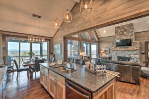 a kitchen and living room with a couch and a fireplace at Luxurious Mountain Getaway with Game Room and Hot Tub! in Mineral Bluff