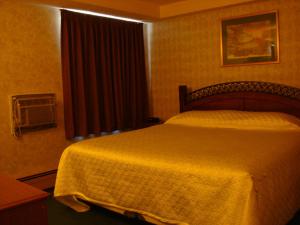 Un dormitorio con una cama con una manta amarilla encima. en Blue Bird Hotel, en Melfort
