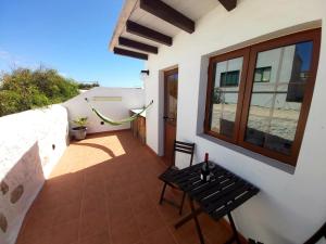 - Balcón de casa con mesa y ventana en LUANA APARTMENT, en Teguise