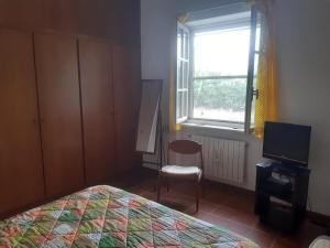 - une chambre avec un lit, une chaise et une fenêtre dans l'établissement la casa di Mario, à Itri
