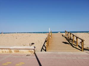 a wooden boardwalk leading to a sandy beach at APARTAMENTOS MAITE in Peniscola