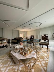 sala de estar con sofá, mesa y sillas en شالية فاخر بمسبح خاص بمكة المكرمة en Makkah