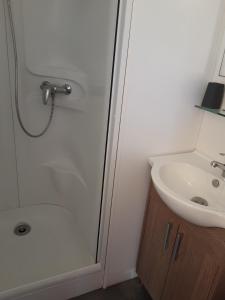 a bathroom with a shower and a sink at Camping du Parc de La Fecht in Munster