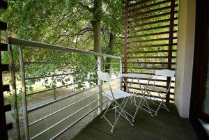 a porch with two chairs and a table on it at Apartamenty Świnoujście - Zacisze Leśne in Świnoujście