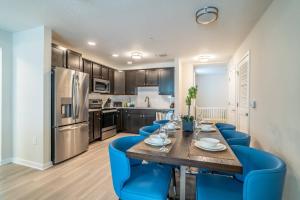 a kitchen with a dining room table and blue chairs at 4013 Vista Cay 2 in Orlando