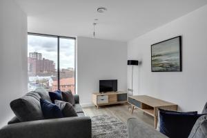 a living room with two couches and a tv at Amazing Apartment in the heart of Birmingham in Birmingham
