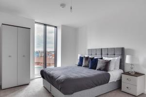 a white bedroom with a bed and a window at Amazing Apartment in the heart of Birmingham in Birmingham