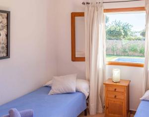 
a bedroom with a bed and a window at Villa Es Cubells 204 in Es Cubells
