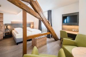 a hotel room with a bed and a tv at Hotel Café Adler in Triberg