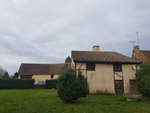 ein altes Haus in einem Hof mit einem Grasfeld in der Unterkunft Gite l'Escale in Gigny-sur-Saône