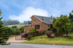 a house with a red truck parked in front of it at Agape holiday house in Herolds Bay