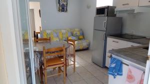 a small kitchen with a table and a couch at La belle étape in Sérignan