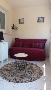 a living room with a red couch and a table at La belle étape in Sérignan