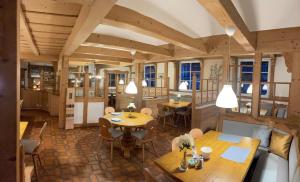 a dining room with tables and chairs and windows at Hotel Adler in Bad Friedrichshall