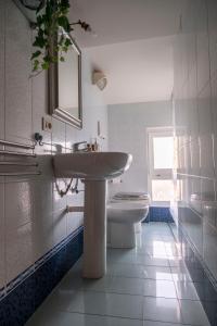 a white bathroom with a sink and a toilet at Residenza Roma in Pistoia