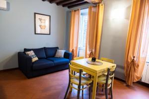 ein Wohnzimmer mit einem Tisch und einem blauen Sofa in der Unterkunft Residenza Roma in Pistoia