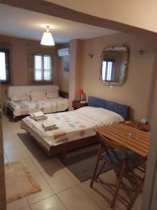 a bedroom with two beds and a table and a desk at new style in the neighborhood in Ermoupoli