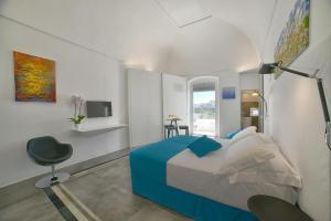 a bedroom with a bed and a desk and a chair at Sunshine Luxury Rooms in Ostuni