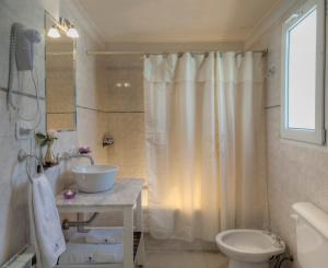 uma casa de banho com um chuveiro, um lavatório e um WC. em NBH Lacus Boutique Hotel em San Carlos de Bariloche