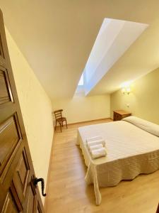 - une chambre mansardée avec un lit et une lucarne dans l'établissement La Parada de Jimena-Casa rústica rodeada de bodegas en Rueda, à Rueda