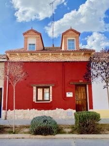 a red building with a tower on top of it at La Parada de Jimena-Casa rústica rodeada de bodegas en Rueda in Rueda