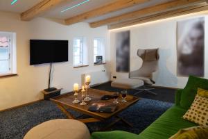 uma sala de estar com um sofá verde e uma televisão em fewo1846 - Lille hus - reizvolles Kapitänshäuschen am Hafen über 3 Ebenen em Flensburg