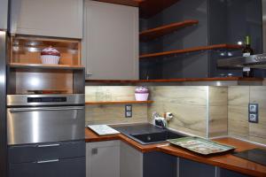 uma cozinha com um lavatório e um frigorífico de aço inoxidável em 3h Anthi Comfort apt near Athens em Atenas