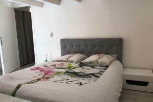 ein Schlafzimmer mit einem Bett mit Blumen darauf in der Unterkunft La Tournette - Apartment for 2-4 people in the heart of the old town in Annecy