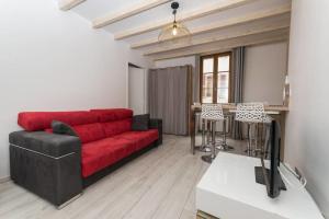 ein Wohnzimmer mit einem roten Sofa und einem Tisch in der Unterkunft La Tournette - Apartment for 2-4 people in the heart of the old town in Annecy