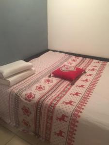 a bed with a red pillow and towels on it at The chalet de la Meije - Facing the Plateau d'Emparis in La Grave