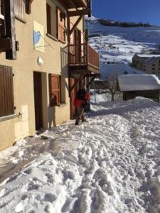 a person walking down a snow covered sidewalk next to a building at The chalet de la Meije - Facing the Plateau d'Emparis in La Grave