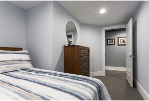 um quarto com uma cama e uma cómoda com um espelho em Forrestville Ave Large Suite em Chicago