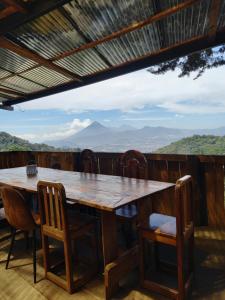 a table and chairs on a deck with mountains in the background at Vista Encantada Hotel in Villa Canales +28 photos