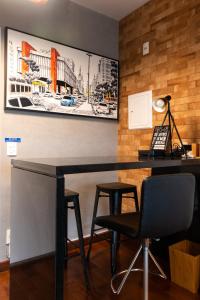 a desk and two chairs in a room with a picture on the wall at Rosemari's Apartments SJ Urban Chic in Sao Paulo
