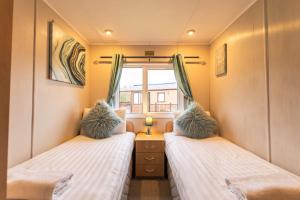 Woodland Lodge With Hot Tub tesisinde bir odada yatak veya yataklar