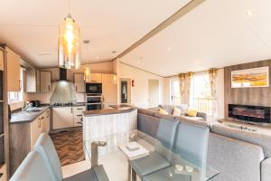 a kitchen and living room with a couch and a table at Springwell Lodge With Hot Tub in Malton