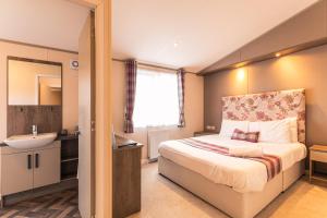 a small bedroom with a bed and a sink at Springwell Lodge With Hot Tub in Malton