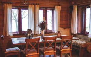 jadalnia ze stołem, krzesłami i oknami w obiekcie Znam Ten Widok - Bieszczady w mieście Ustrzyki Dolne