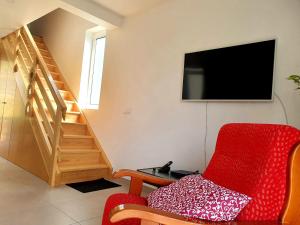 ein Wohnzimmer mit einem roten Sessel und einem Fernseher in der Unterkunft Zef's chalet in Senhora do Rosário