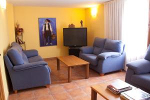 a living room with two chairs and a tv at Hotel Casa Duaner in Guardiola de Berguedà