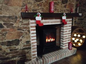 a fireplace decorated for christmas with santa claus decorations at Casa Rural Mi Descanso in Valdefuentes de Sangusín