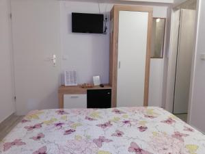a bedroom with a bed with a floral bedspread at Rooms Radic in Dubrovnik