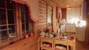 una cocina con mesa en una cabaña de madera en Holiday Cabin Kerimaa 102 en Savonlinna